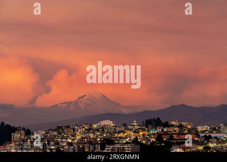 Paesaggio urbano di Quito al tramonto con il vulcano Cayambe, Ecuador. Foto Stock