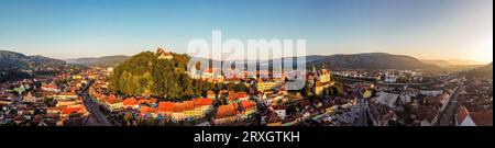 Panorama aereo all'alba della fortezza medievale e della città di Sighisoara. Foto scattata il 18 agosto 2023 a Sighisoara, Transilvania, Romani Foto Stock
