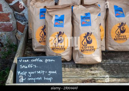 Sacchetti di fondi di caffè usati da prendere, con la lettura dei cartelli buoni per la raccolta di compost Foto Stock