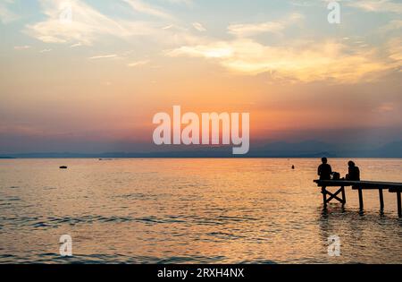 Vista sul lago al tramonto dalla passerella di Cisano, Bardolino, Lago di Garda, Italia Foto Stock