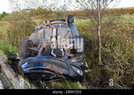 A6033 Road, West Yorkshire. 25 settembre 2023. RTA, incidente stradale sulla A6033 tra Pecket Well e Oxenhope con la vettura capovolta e la portiera del conducente aperta. L'auto era una Vauxhall Astra Diesel del 2008 basata sulla targa posteriore. Il conducente non era presente. Nessun nastro della polizia sopra o in prossimità della vincinità del veicolo o della polizia presente. L'interno dell'auto sembrava intatto, nessun danno evidente, segni di lesioni o sangue. Le auto rallentavano e chiedevano se qualcuno fosse intrappolato all'interno. Crediti: Stephen Bell/Alamy Live News Foto Stock