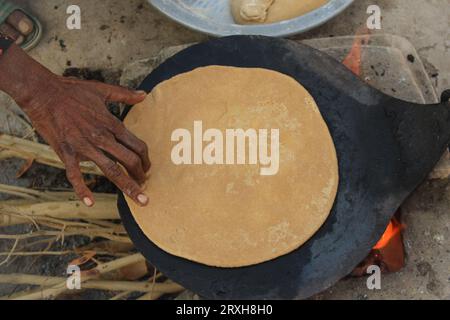 Primo piano di mani di una donna asiatica che fa roti in cucina. Concetto di preparazione rurale di chapati pakistani o indiani. Villaggio pakistano W Foto Stock