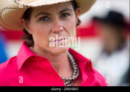 La regina del rodeo posa un ritratto davanti a una bandiera americana; Burwell, Nebraska, Stati Uniti d'America Foto Stock