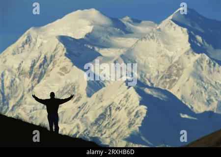 Escursionista che si staglia contro il Monte McKinley innevato nel Denali National Park and Preserve, Alaska, Stati Uniti d'America Foto Stock