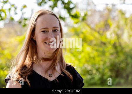 Ritratto all'aperto di una bella donna in un parco cittadino durante un caldo pomeriggio autunnale; Leduc, Alberta, Canada Foto Stock