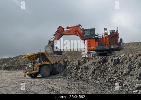 WESTPORT, NUOVA ZELANDA, 12 LUGLIO 2013: Una scavatrice da 190 tonnellate carica un camion da 130 tonnellate con copertura di roccia nella miniera di carbone aperta di Stockton il 12 luglio 2013 nea Foto Stock