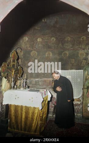 Sitaru, Contea di Ialomita, Romania, circa 2000. Interno della chiesa cristiana ortodossa del XVIII secolo nel villaggio di Sitaru (ex Grecii de Mijloc). Sacerdote di fronte alla Tavola dell'altare nel Santuario. Foto Stock