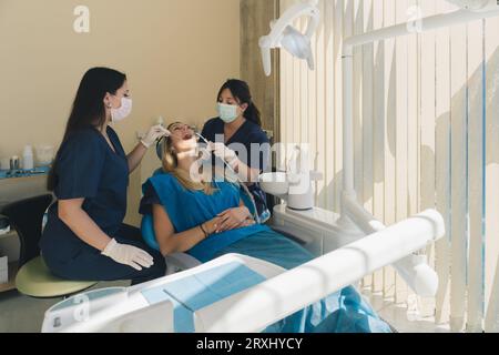 Dentista che esamina i denti di una paziente donna e fa un controllo dentale presso la clinica odontoiatrica. Foto Stock