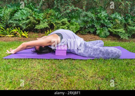 Donna che si rilassa sui blocchi di yoga. Copia spazio Foto Stock