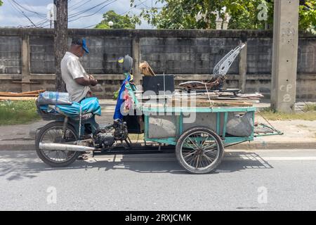 SAMUT PRAKAN, THAILANDIA, 19 settembre 2023, Un uomo con un triciclo carico di tavole usate parchi per strada Foto Stock