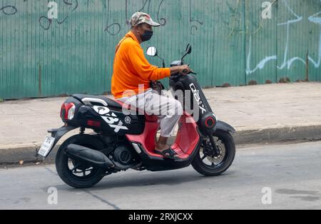 SAMUT PRAKAN, THAILANDIA, 19 settembre 2023, Un uomo guida una motocicletta in una strada cittadina Foto Stock