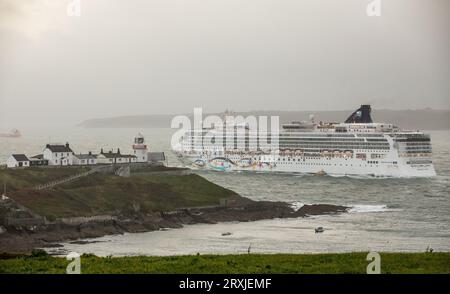 Roches Point, Cork, Irlanda. 25 settembre 2023. Con una nebbia disidratante, la nave da crociera Norwegian Star passa davanti al faro di Roches Point, Co.. Cork al crepuscolo mentre salpa per Dingle, Co. Kerry. - Credito: David Creedon / Alamy Live News Foto Stock