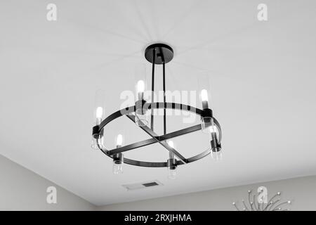 Elegante lampada rotonda con telaio nero in metallo con sei luci e design moderno Foto Stock