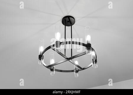 Elegante lampada rotonda con telaio nero in metallo con sei luci e design moderno Foto Stock