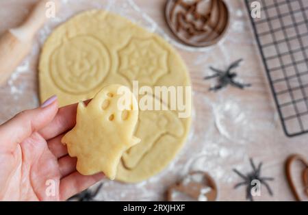 Preparazione di biscotti per le feste da cuocere in forno. Biscotti di Halloween pronti da cuocere a forma di zucche e fantasmi Foto Stock