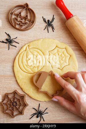 Preparazione di biscotti per le feste da cuocere in forno. Biscotti di Halloween pronti da cuocere a forma di zucche e fantasmi Foto Stock