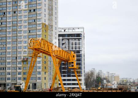 Un grande e moderno cantiere per la costruzione di edifici e case con elettrodomestici e molte grandi torri alte e energia industriale stazionaria Foto Stock