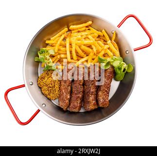 Involtini di carne rumeni alla griglia chiamati mititei o mici serviti con patatine fritte e senape di digione. Cibo tradizionale rumeno Foto Stock