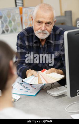 designer di interni senior che mostra i campioni durante la riunione Foto Stock