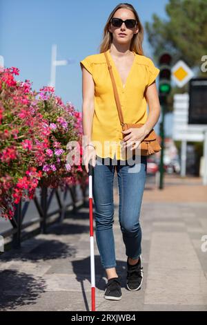 una giovane donna affascinante che cammina con un bastoncino Foto Stock