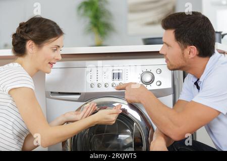 coppia che guarda la lavatrice Foto Stock