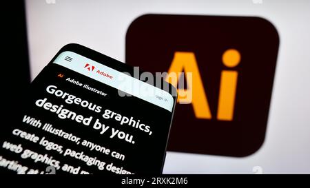 Telefono cellulare con sito Web dell'editor di grafica vettoriale Adobe Illustrator sullo schermo davanti al logo aziendale. Mettere a fuoco in alto a sinistra sul display del telefono. Foto Stock