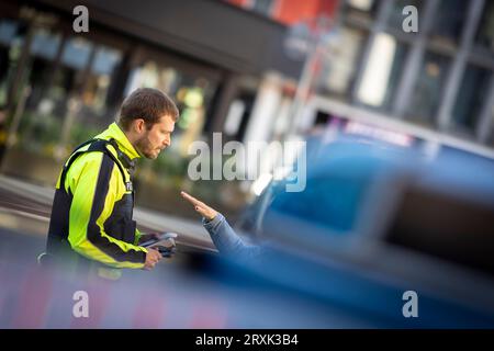 Hannover, Germania. 26 settembre 2023. Un poliziotto parla con un autista donna durante un controllo del traffico. Gli agenti di polizia controllano le distanze laterali dei veicoli durante il sorpasso dei ciclisti a Königsstraße. La polizia della bassa Sassonia partecipa a una giornata di azione interstatale per una maggiore sicurezza stradale questo martedì (26.09.2023). Credito: Moritz Frankenberg/dpa/Alamy Live News Foto Stock