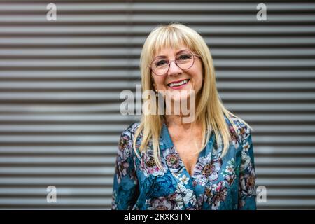 Ritratto di una donna anziana felice con occhiali da vista in piedi all'aperto Foto Stock