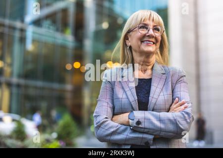 Ritratto di una donna d'affari anziana sorridente in città Foto Stock