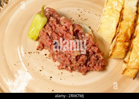 Tartaro di manzo crudo servito con pane di segale tostato da vicino. Menu pronto. Messa a fuoco selettiva Foto Stock