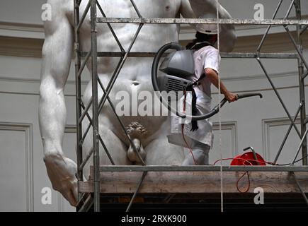 La restauratrice italiana Eleonora Pucci pulisce polvere e detriti dalla famosa statua in marmo del David di Michelangelo alla Galleria dell'Accademia di Firenze, Italia, il 25 settembre 2023. Il restauratore trascorre un giorno spolverando la statua di 5,17 metri. Il processo ha luogo ogni due mesi. Utilizza una serie di spazzole morbide e un aspirapolvere a bassa pressione per rimuovere delicatamente la polvere e i depositi di sporcizia che inevitabilmente si verificano quando ci sono così tanti visitatori che si affollano per vedere i capolavori. La statua è stata realizzata dal maestro italiano tra il 1501-1504 da un blocco di marmo. Rappresenta il Bi Foto Stock