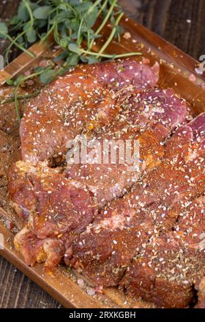 Pezzi di carne di maiale marinati con spezie e sale, collo di maiale preparato per la cottura con spezie miste con sale marino Foto Stock