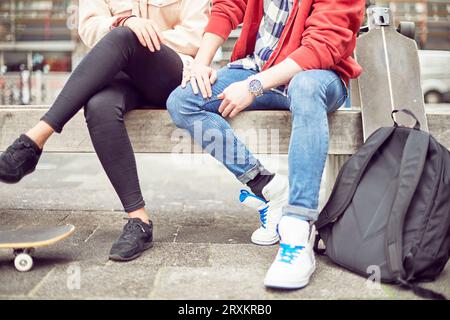 Le gambe del giovane adolescente seduti insieme Foto Stock