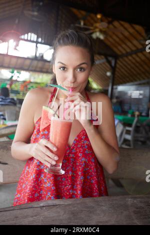 Giovane donna bere drink di cocomero Foto Stock