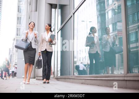 Donne d'affari che camminano sul marciapiede Foto Stock