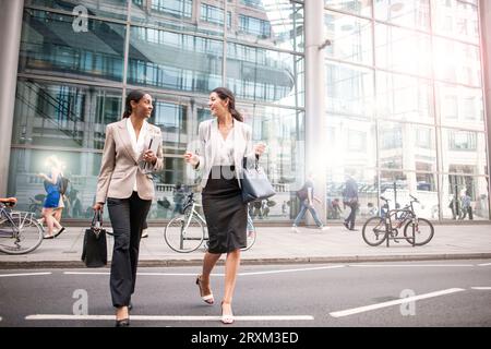 Donne d'affari che attraversano la strada Foto Stock