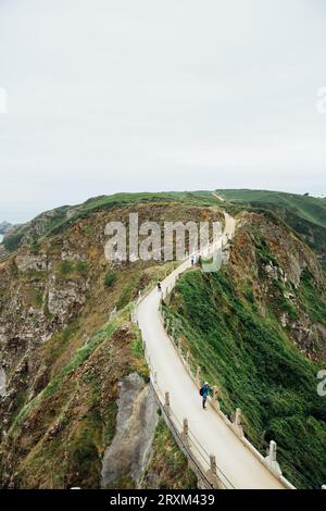 I turisti camminano su una strada collinare Foto Stock