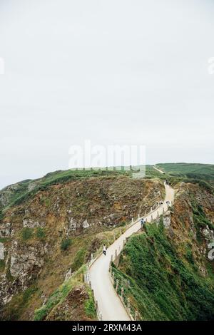 I turisti camminano su una strada collinare Foto Stock