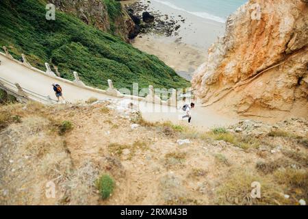 I turisti camminano su una strada collinare Foto Stock