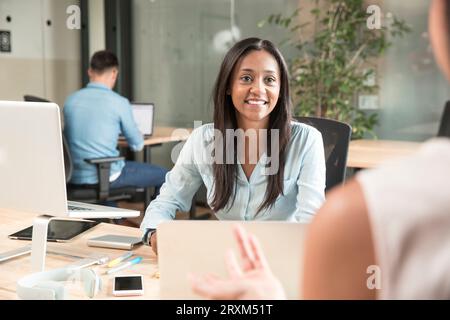 Metà donna adulta sorridente durante la riunione Foto Stock