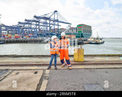 I lavoratori portuali con tavoletta digitale al porto di Felixstowe, Inghilterra Foto Stock