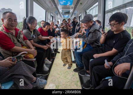 (230926) -- WUHAN, 26 settembre 2023 (Xinhua) -- i passeggeri sperimentano un nuovo servizio sospeso di linea monorotaia a Wuhan, nella provincia centrale di Hubei della Cina, 26 settembre 2023. La prima linea commerciale sospesa della monorotaia della Cina è stata aperta al pubblico martedì a Wuhan, capitale della provincia di Hubei della Cina centrale. La monorotaia sospesa opera per 12 ore al giorno, con una monorotaia che parte ogni 10 minuti. La velocità massima di funzionamento del treno monorotaia è di 60 km all'ora. L'intero processo operativo, compreso l'avviamento, l'ingresso nelle stazioni, l'apertura e la chiusura delle porte, è completamente automatizzato e requ Foto Stock