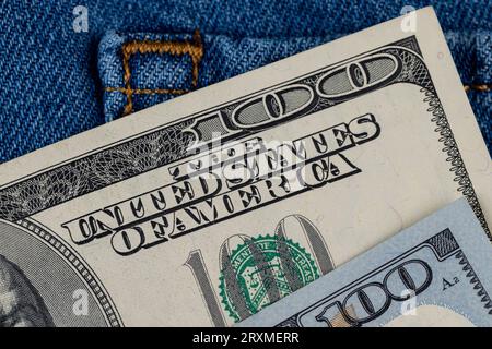 Contanti American cento dollari fatture giacendo nella tasca dei jeans, dollari americani primo piano Foto Stock