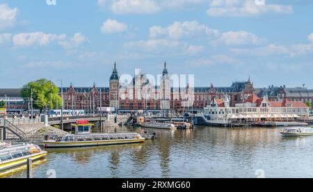 Amsterdam, Paesi Bassi - 20 luglio 2023: Vista panoramica della stazione centrale con il canale Foto Stock