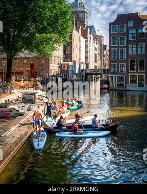 Amsterdam, Paesi Bassi - 20 luglio 2023: Fai paddle board nel canale di Amsterdam la mattina presto. Foto Stock