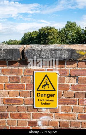 Pericolo fili sotto tensione sotto il cartello di avvertenza British Rail sul viadotto Foto Stock