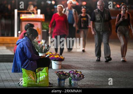 Non esclusiva: ZAPORIZHZHIA, UCRAINA - 25 SETTEMBRE 2023 - le donne vendono fiori per strada la sera, Zaporizhzhia, Ucraina sud-orientale. Foto Stock