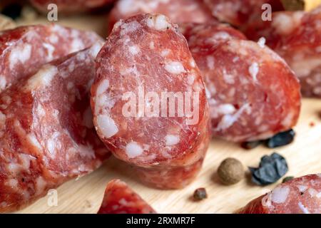 Salsiccia di vitello essiccata durante l'affettatura, preparazione di snack da salsiccia di vitello essiccata Foto Stock