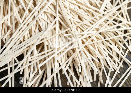 spaghetti sottili di farina di riso sul tavolo, spaghetti di riso crudi secchi in cucina Foto Stock