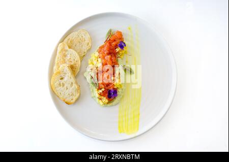 Tartare di salmone con crema di avocado alla menta e mango e crostini di ciabatta. Foto di alta qualità Foto Stock